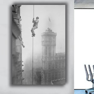 May include: Black and white photograph of a man climbing a rope on a building. The image is a vintage print, showing a tall building with a flag on top. The scene is set in a foggy environment, adding a sense of mystery.