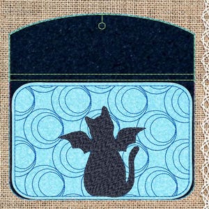 May include: A black cat with wings is silhouetted against a blue and white background of circles. The cat is sitting with its tail curled around its legs. The background is a light blue with dark blue circles.