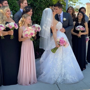 Daughter of the bride, flower girl in blush sheer chiffon tulle infinity dress with groom kissing bride