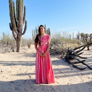 Sunrise Coral Velvet Infinity Wrap Dress worn on one shoulder standing in the desert surrounded by cactus.
