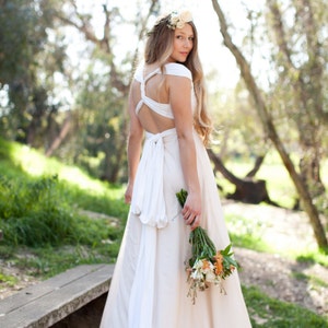 Woman in whimsical layered tulle Infinity Wrap Wedding dress with back twisted holding bouquet