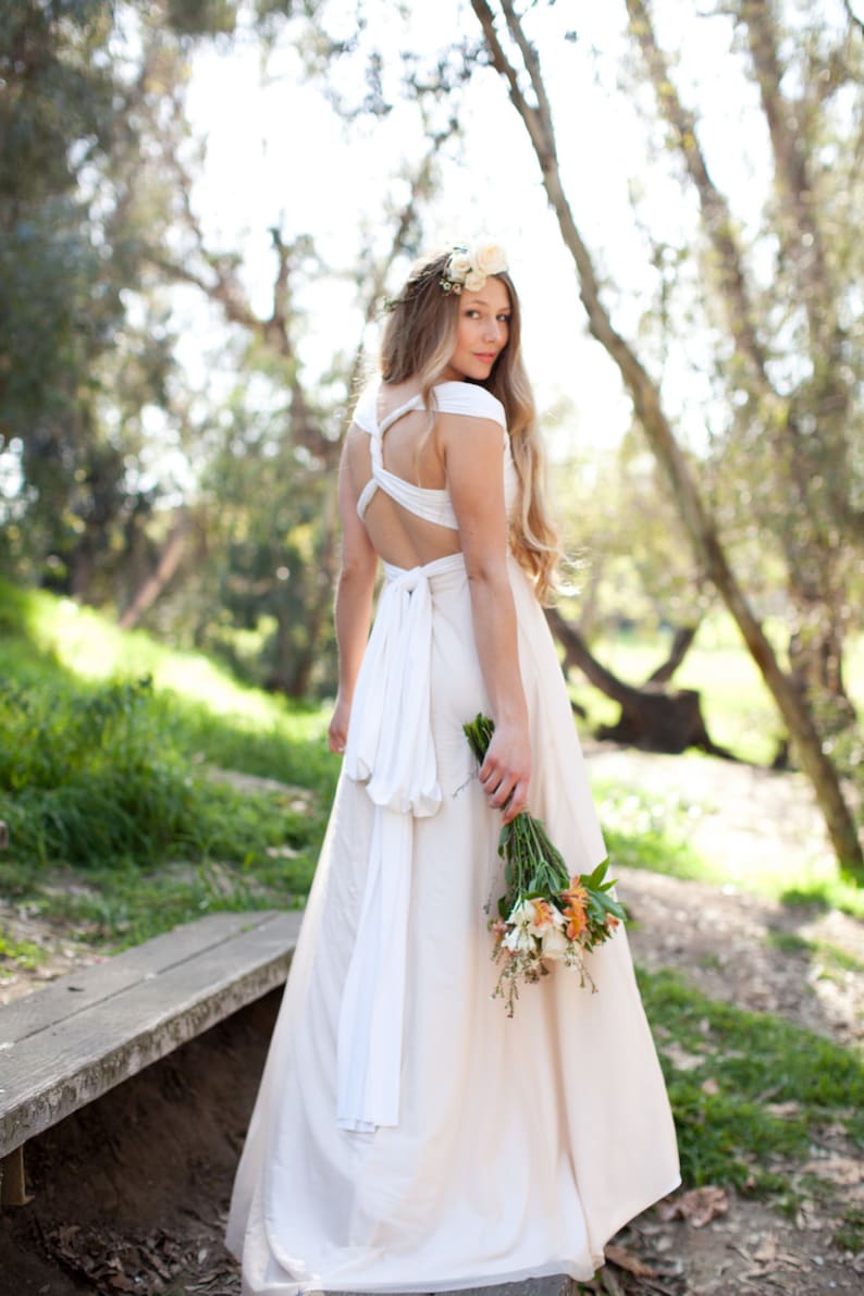 Woman in whimsical layered tulle Infinity Wrap Wedding dress with back twisted holding bouquet