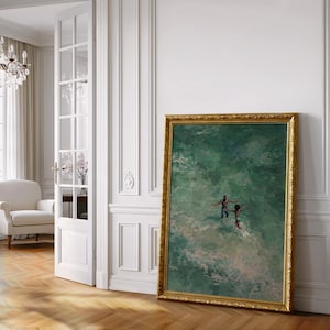 May include: A framed painting with a gold ornate frame leans against a white wall. The painting depicts two figures in green water. The room has a white door with glass panels, a white chair, and a chandelier.