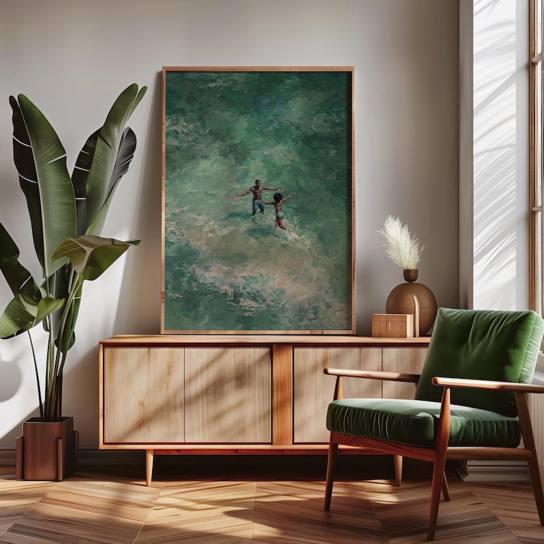 Mid-century modern interior mockup with African American beach wall art in a natural wood frame on a sideboard. This ocean oil painting features a Black couple in turquoise water, perfect for coastal summer decor and Black love art.