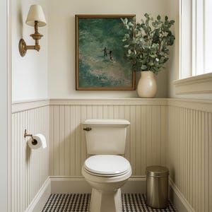 Classic bathroom decor mockup with African American art in a thin gold frame hanging above a toilet. This turquoise ocean oil painting of a romantic Black couple adds a refreshing beach wall art feel to coastal summer decor themes.