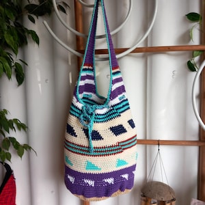 Spacious, crocheted shopping bag with an indigenous pattern and drawstring closure. 33 x 32 cm with an integrated carrying strap.
