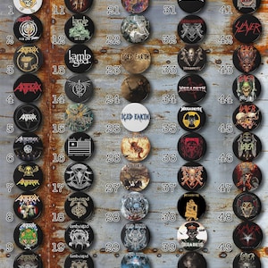 May include: A grid of 50 round metal pins with various band logos. The logos include bands such as Anthrax, Iced Earth, Lamb of God, Megadeth, and Slayer. The pins are arranged in rows of 10, with each row numbered 1 through 10.
