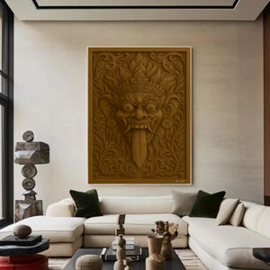 Peut inclure: Un grand cadre en bois brun sculpté d'un masque de Barong balinais. Le masque a de grands yeux, une longue langue et est entouré de sculptures florales et de feuilles ornées. L'œuvre est exposée dans un salon moderne.