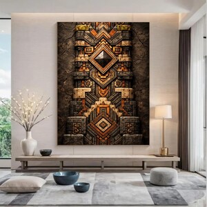 May include: A large rectangular artwork with a detailed geometric design in brown, orange, and grey. The textured piece features a central diamond shape and stepped patterns. The artwork is displayed in a modern living room setting, with a floor lamp and a low table.