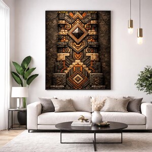 May include: A large framed wall art piece with a geometric design in shades of brown, grey, and orange. The artwork features a central diamond shape and layered patterns, creating a textured, three-dimensional effect. The art is displayed above a white sofa.