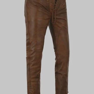 May include: Brown leather trousers with lace-up detailing at the front and ankles. The trousers feature a classic five-pocket design and a straight leg cut. The leather has a slightly distressed appearance.