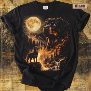 May include: A black t-shirt featuring a graphic print of a Rottweiler dog standing on a rock near a waterfall, with a large, glowing full moon and a larger, ethereal Rottweiler head in the night sky. The text "Black" appears in the top right corner.