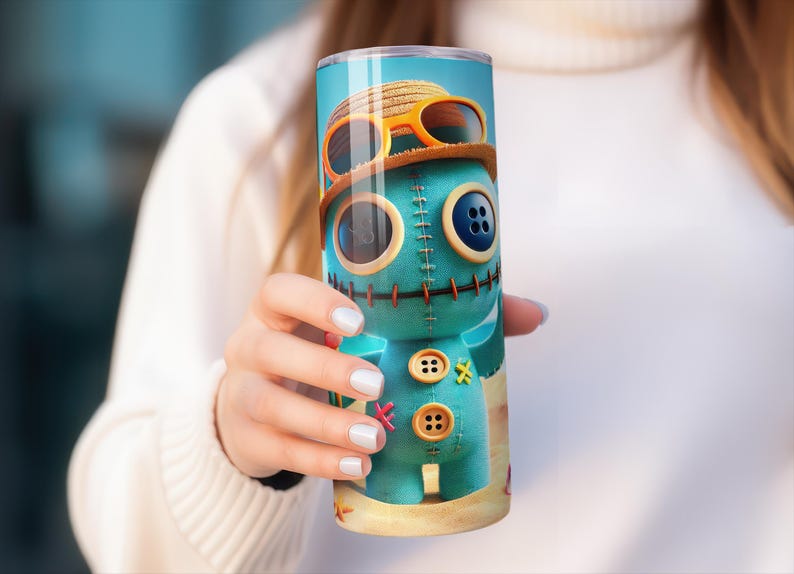May include: A teal tumbler featuring a cartoon character with button eyes, stitched details, and a straw hat with sunglasses. The design includes a beach scene at the bottom. The tumbler is cylindrical and appears to be made of stainless steel.