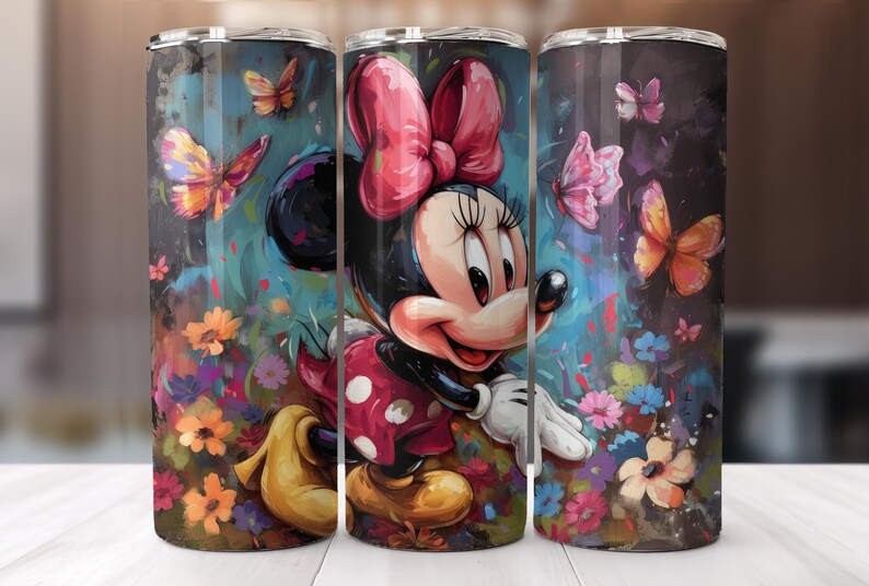 May include: A tumbler featuring a colorful illustration of Minnie Mouse surrounded by butterflies and flowers. The design includes a large red bow, a polka-dot dress, and a vibrant floral background. The tumbler is cylindrical and has a silver lid.