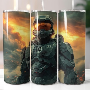 May include: A set of three stainless steel tumblers featuring a detailed image of a futuristic soldier in green armor with an orange visor, set against a fiery sunset backdrop. Each tumbler includes a white straw.