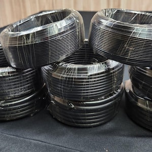 May include: Multiple spools of black electrical wire wrapped in clear plastic. The wire is bundled together and ready for use.