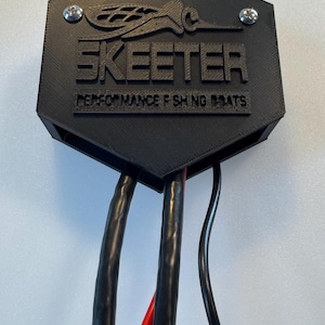 May include: A black hexagonal box with the text "SKEETER PERFORMANCE FISHING BOATS" printed on it.  The box has four black wires coming out of it.