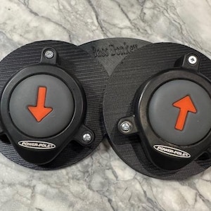 May include: Two black round buttons with a red arrow pointing up and down. The buttons have the text "Power-Pole" printed on them.