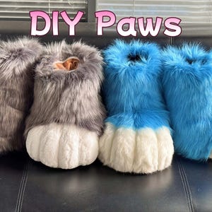 May include: Four furry DIY paws in the image. Two are gray with white paw pads, and two are bright blue with white paw pads. The text "DIY Paws" is above the paws in pink letters.