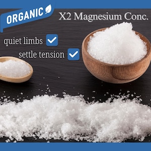 Puede incluir: Imagen de un cuenco y una cuchara de madera llenos de gr&aacute;nulos cristalinos blancos, con las etiquetas "X2 Magnesium Conc." y "Organic". El texto indica beneficios: "piernas tranquilas" y "aliviar la tensi&oacute;n."