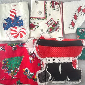Könnte beinhalten: Eine Sammlung von Stoffstücken zum Thema Weihnachten. Enthält ein rot-weißes Zuckerstangen-Design, einen roten Stoff mit einem Weihnachtsbaum und Zeichentrickfiguren sowie ein Weihnachtsmann-Anzug-Design. Weitere Stücke zeigen Weihnachtsmuster.