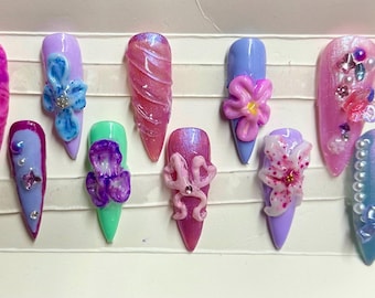 Uñas postizas de gel con diseño floral 3D, morado y azul, con forma de aguja larga, prensadas.