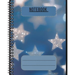 Peut inclure: Cahier à spirales avec une couverture bleue ornée d'étoiles. Le mot "NOTEBOOK" est affiché dans un rectangle bleu clair en haut. L'arrière-plan présente un effet bokeh avec des étoiles floues.