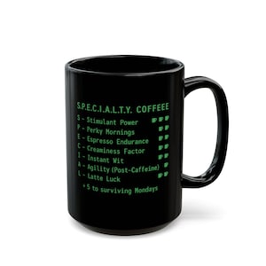 May include: Black ceramic coffee mug with a large handle. The mug features green text that reads "S.P.E.C.I.A.L.T.Y. COFFEEE" and a list of coffee-related attributes. The mug is designed for coffee lovers.