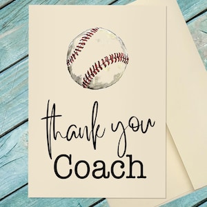 May include: A cream-colored greeting card featuring a watercolor illustration of a white baseball with red stitching at the top. Below the baseball, the text reads "thank you" in a black cursive script, followed by the word "Coach" in black print.
