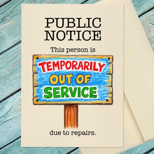 May include: A greeting card with a cream background featuring a hand-drawn illustration of a wooden sign. The text reads PUBLIC NOTICE, This person is, TEMPORARILY OUT OF SERVICE, and due to repairs. The sign is blue with red and green lettering.
