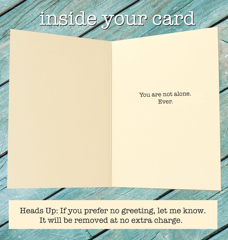 May include: An open greeting card with a cream-colored interior. The text "inside your card" is at the top. The right side of the card reads "You are not alone. Ever." Below, the text reads "Heads Up: If you prefer no greeting, let me know."