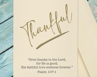 May include: A cream-colored greeting card featuring the word Thankful in large gold script lettering. Below the script, the text reads: Give thanks to the Lord, for He is good; His faithful love endures forever. Psalm 107:1. A matching envelope is included.
