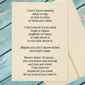 May include: A cream-colored greeting card with a heartfelt message printed in black. The text offers support and reassurance, with phrases like "you are brave and strong, and you are loved." The card is accompanied by a matching envelope.