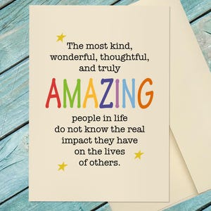 May include: A cream-colored greeting card with black text that reads: The most kind, wonderful, thoughtful, and truly AMAZING people in life do not know the real impact they have on the lives of others. The word AMAZING is in rainbow colors.