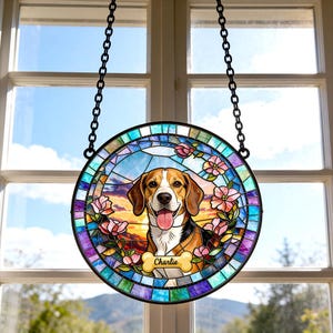 May include: A round, stained-glass window hanging featuring a beagle dog with a happy expression. The dog is surrounded by pink flowers and a colorful border. The name "Charlie" is on a bone-shaped plaque.