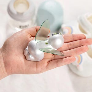 Scultura commemorativa personalizzata con pietra portafortuna raffigurante un bambino addormentato, con ali d'angelo o di farfalla, regalo di condoglianze per la perdita di un neonato da parte della mamma.