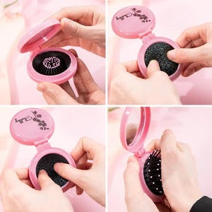 Può includere: Una spazzola per capelli pieghevole rosa compatta con specchio. La spazzola ha setole nere e un involucro rosa. La parte superiore del compatto ha la parola "Shelly" e un motivo floreale. Il compatto è mostrato aperto e chiuso.