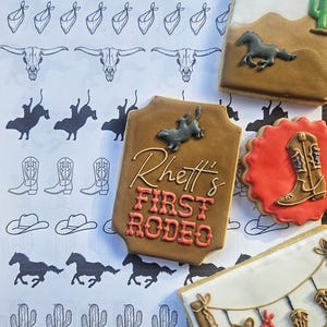 Puede incluir: Un conjunto de seis galletas de az&uacute;car decoradas con un tema del oeste. Las galletas representan a un vaquero montando un bronco salvaje, una bota, un cactus, una herradura, un pa&ntilde;uelo, un sombrero de vaquero, una calavera y un cartel que dice "Rhett's First Rodeo".