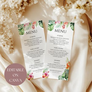 May include: Two wedding menu cards with floral and leaf designs. The cards display the word "MENU" at the top, followed by the menu items: Smoked Salmon Crostini, Grilled Filet Mignon, and Tiramisu. The text "EDITABLE ON CANVA" is also visible.