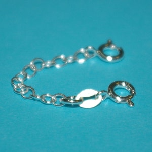 May include: A silver chain extender with two lobster claw clasps. The chain is made of small, round links.