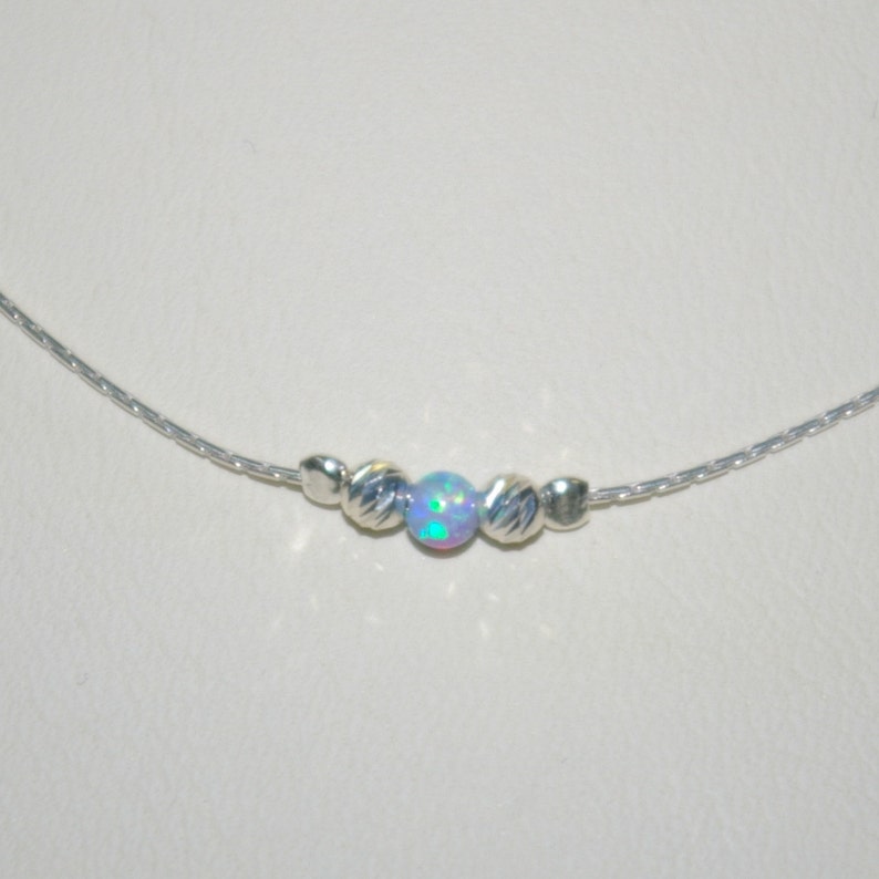 May include: A silver chain necklace with a single iridescent opal bead and two silver beads on either side.