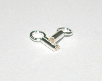 May include: Two silver-toned metal end caps with a loop on one end and a cylindrical tube on the other. The tube has a small hole on each end.