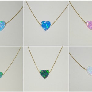 May include: Six gold necklaces with heart-shaped opal pendants in various colors, including blue, green, pink, and white.