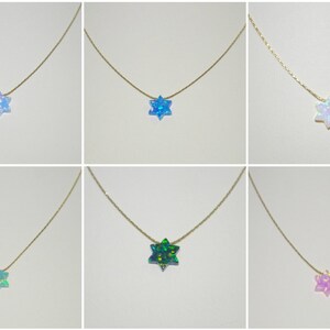 May include: Six gold necklaces with a star of David pendant made of iridescent opal. The opals are in various colors, including blue, green, pink, and white.