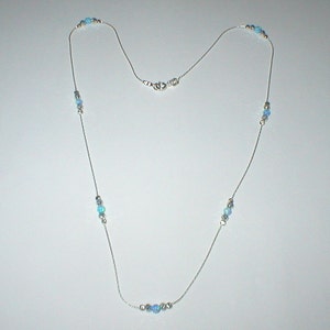 May include: A silver chain necklace with light blue opal beads. The necklace has a lobster clasp closure.