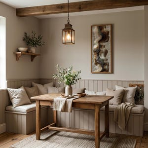 May include: A cozy dining area with a wooden table, benches, and a rug. A framed abstract artwork hangs on the wall. A lantern hangs above the table. Pillows and a vase with flowers add to the room's inviting atmosphere.