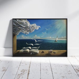 May include: Framed art print depicting a surreal seascape. A book with pages turning into birds sits on a wooden ledge, with a sailboat on the ocean. White fabric billows in the upper left corner, with seagulls flying in the sky.