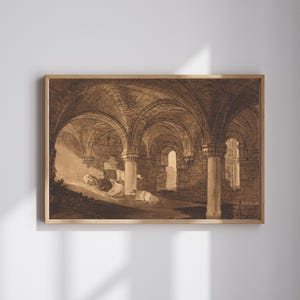 May include: Sepia-toned print depicting an arched interior with stone columns and a vaulted ceiling. Figures are visible in the foreground, illuminated by light from a window. The artwork is framed in a light brown wooden frame.
