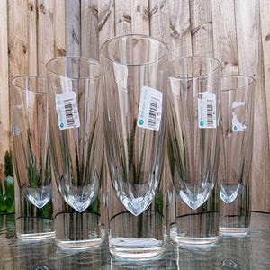 May include: A set of five clear glass vases, each featuring a cylindrical exterior and a tapered, bullet-shaped interior cavity. Each vase has a white rectangular product label with a barcode and the text Borgonovo Italy attached to the side.