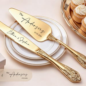 May include: A gold-toned cake knife and server set with ornate handles. The knife is engraved with the text Ethan & Sophia, and the server features the text The Andersons and 07.05.2026. The utensils are resting on a white plate with gold trim.